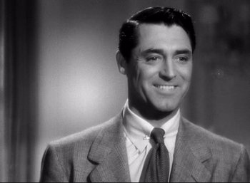 Movie still from “Suspicion” (1941), directed by Alfred Hitchcock – A black and white photo of a man in a suit and tie; Close Up shot, Low angle