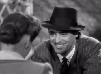 Movie still from “Suspicion” (1941), directed by Alfred Hitchcock – A man wearing a hat sitting next to a woman; Close Up shot, Over the shoulder angle