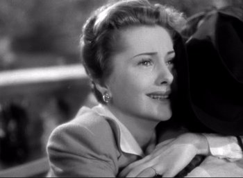 Movie still from “Suspicion” (1941), directed by Alfred Hitchcock – An old photo of a woman smiling at the camera; Close Up shot, High angle