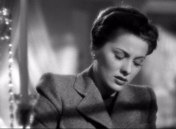Movie still from “Suspicion” (1941), directed by Alfred Hitchcock – An old photo of a woman in a suit; Close Up shot, Low angle