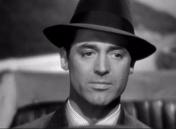 Movie still from “Suspicion” (1941), directed by Alfred Hitchcock – A black and white photo of a man wearing a hat; Close Up shot, Over the shoulder angle