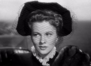 Movie still from “Suspicion” (1941), directed by Alfred Hitchcock – An old photo of a woman wearing a black hat; Close Up shot, Low angle