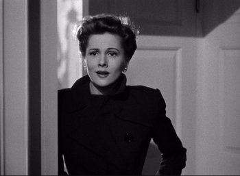 Movie still from “Suspicion” (1941), directed by Alfred Hitchcock – An old photo of a woman standing in front of a door; Close Up shot, Low angle