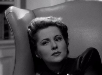 Movie still from “Suspicion” (1941), directed by Alfred Hitchcock – An old black and white photo of a woman sitting in a chair; Close Up shot, High angle