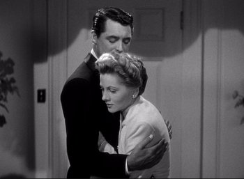 Movie still from “Suspicion” (1941), directed by Alfred Hitchcock – A man and a woman hugging in a black and white photo; Medium shot, Low angle