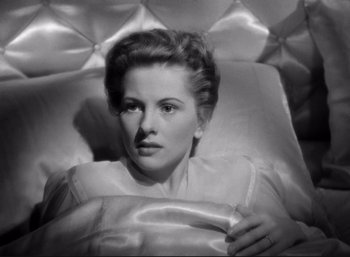 Movie still from “Suspicion” (1941), directed by Alfred Hitchcock – An old black and white photo of a woman laying in a bed; Close Up shot, High angle
