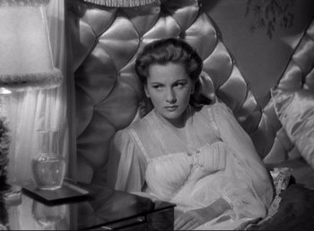 Movie still from “Suspicion” (1941), directed by Alfred Hitchcock – A black - and - white photo of a woman sitting in a chair; Medium shot, High angle