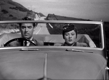 Movie still from “Suspicion” (1941), directed by Alfred Hitchcock – A man and a woman in the back seat of a car; Medium shot, Low angle