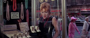 Movie still from “Sweet Charity” (1969), directed by Bob Fosse – A woman standing in front of a store window; Medium shot, Over the shoulder angle
