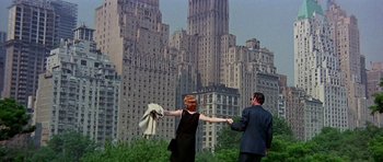 Movie still from “Sweet Charity” (1969), directed by Bob Fosse – A man and a woman holding hands in front of a city skyline; Wide shot, Low angle