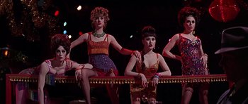 Movie still from “Sweet Charity” (1969), directed by Bob Fosse – A group of women sitting next to each other on top of a stage; Medium shot, Low angle