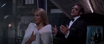 Movie still from “Sweet Charity” (1969), directed by Bob Fosse – A man and a woman in a white fur coat clapping; Medium shot, Over the shoulder angle