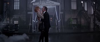 Movie still from “Sweet Charity” (1969), directed by Bob Fosse – A man and a woman kissing under an awning; Wide shot, Low angle
