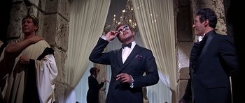 Movie still from “Sweet Charity” (1969), directed by Bob Fosse – A man in a suit and sunglasses looking up; Medium shot, Low angle