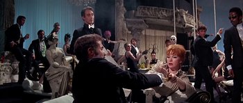 Movie still from “Sweet Charity” (1969), directed by Bob Fosse – A group of people sitting in a room; Medium shot, Over the shoulder angle