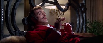 Movie still from “Sweet Charity” (1969), directed by Bob Fosse – A man sitting in a chair holding a cigarette in his mouth; Close Up shot, Low angle