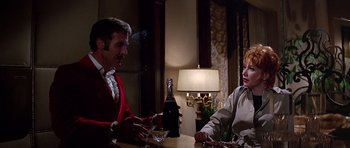 Movie still from “Sweet Charity” (1969), directed by Bob Fosse – A man and a woman sitting at a table with a bottle of wine; Medium shot, Over the shoulder angle