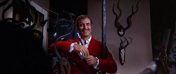 Movie still from “Sweet Charity” (1969), directed by Bob Fosse – A man in a red jacket holding a pair of scissors; Medium shot, Low angle