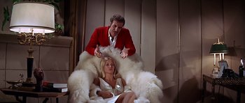 Movie still from “Sweet Charity” (1969), directed by Bob Fosse – A woman sitting in a chair with a man in a red jacket; Medium shot, Low angle