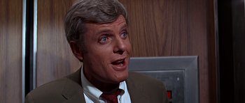 Movie still from “Sweet Charity” (1969), directed by Bob Fosse – An older man in a brown suit and red neck tie; Close Up shot, Over the shoulder angle