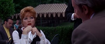 Movie still from “Sweet Charity” (1969), directed by Bob Fosse – A woman sitting next to a man holding a wine glass; Close Up shot, Over the shoulder angle