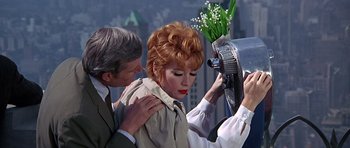 Movie still from “Sweet Charity” (1969), directed by Bob Fosse – A man and a woman looking into a hair dryer; Medium shot, High angle