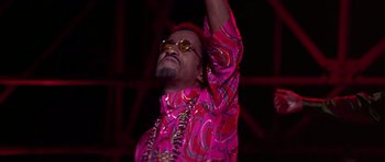 Movie still from “Sweet Charity” (1969), directed by Bob Fosse – A man in a pink shirt and a gold necklace; Medium shot, Low angle