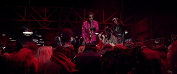 Movie still from “Sweet Charity” (1969), directed by Bob Fosse – A group of people sitting on a stage with a microphone; Medium shot, Low angle