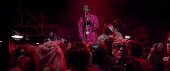 Movie still from “Sweet Charity” (1969), directed by Bob Fosse – A man in a crowd of people in a red room; Medium shot, Low angle