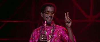 Movie still from “Sweet Charity” (1969), directed by Bob Fosse – A man in a pink shirt holding a glass of wine; Medium shot, Low angle