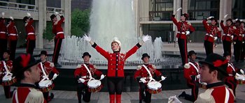 Movie still from “Sweet Charity” (1969), directed by Bob Fosse – A group of men in red and black uniforms playing drums; Wide shot, Low angle