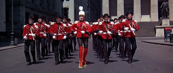 Movie still from “Sweet Charity” (1969), directed by Bob Fosse – A group of men in red and black marching down a street; Wide shot, Low angle