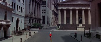 A woman in a red dress standing in the middle of a street