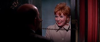 Movie still from “Sweet Charity” (1969), directed by Bob Fosse – An older woman with red hair is smiling in front of a mirror; Close Up shot, Over the shoulder angle