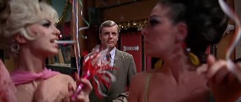 Movie still from “Sweet Charity” (1969), directed by Bob Fosse – A man in a suit and tie standing in front of a woman; Close Up shot, Over the shoulder angle