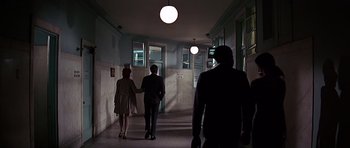 Movie still from “Sweet Charity” (1969), directed by Bob Fosse – Two people walking down a hallway in a building; Wide shot, Low angle