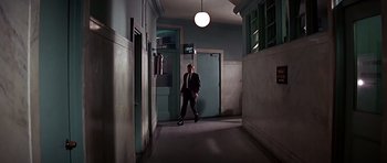 Movie still from “Sweet Charity” (1969), directed by Bob Fosse – A man in a suit standing in a hallway; Wide shot, Low angle