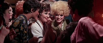 Movie still from “Sweet Charity” (1969), directed by Bob Fosse – A group of people standing around each other in a room; Close Up shot, High angle