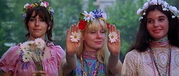 Movie still from “Sweet Charity” (1969), directed by Bob Fosse – A woman wearing a flower crown holding up her hands; Medium shot, Low angle