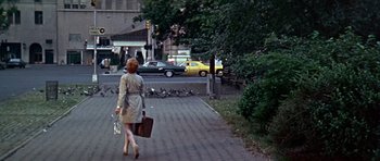 Movie still from “Sweet Charity” (1969), directed by Bob Fosse – A woman walking down the street holding a suitcase; Wide shot, Low angle