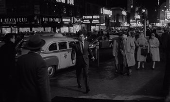 Movie still from “Sweet Smell of Success” (1957), directed by Alexander Mackendrick – A man in a suit and tie walking down a street; Wide shot, High angle