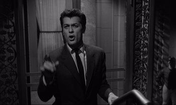 Movie still from “Sweet Smell of Success” (1957), directed by Alexander Mackendrick – Black and white photograph of a man in a suit and tie; Medium shot, Low angle