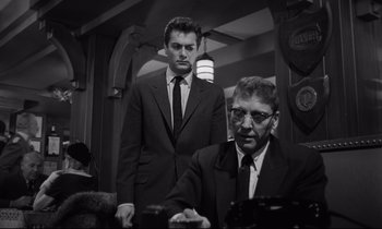 Movie still from “Sweet Smell of Success” (1957), directed by Alexander Mackendrick – A man in a suit standing next to another man in a suit; Medium shot, Low angle
