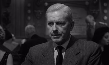 Movie still from “Sweet Smell of Success” (1957), directed by Alexander Mackendrick – An older man wearing a suit and tie; Close Up shot, Low angle