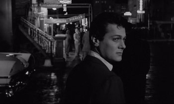 Movie still from “Sweet Smell of Success” (1957), directed by Alexander Mackendrick – A black and white photo of a man standing in the dark; Close Up shot, Low angle