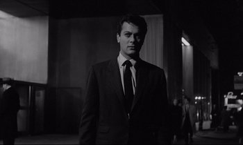 Movie still from “Sweet Smell of Success” (1957), directed by Alexander Mackendrick – A black and white photo of a man wearing a suit and tie; Medium shot, Low angle