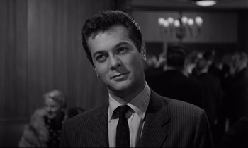 Movie still from “Sweet Smell of Success” (1957), directed by Alexander Mackendrick – Black and white photograph of a man wearing a suit and tie; Close Up shot, Low angle