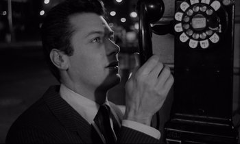 Movie still from “Sweet Smell of Success” (1957), directed by Alexander Mackendrick – A black and white photo of a man in a suit and tie; Close Up shot, Low angle