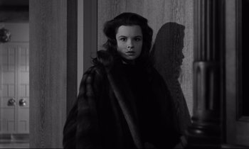 Movie still from “Sweet Smell of Success” (1957), directed by Alexander Mackendrick – A young woman wearing a fur coat standing in front of a wall; Close Up shot, Low angle
