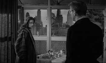 Movie still from “Sweet Smell of Success” (1957), directed by Alexander Mackendrick – A man and a woman standing in front of a window; Medium shot, Over the shoulder angle